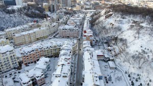 Snow-covered buildings and streets in Kyiv, Ukraine captured from above during winter.