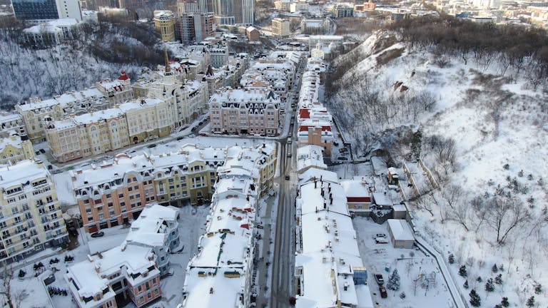 Snow-covered buildings and streets in Kyiv, Ukraine captured from above during winter.
